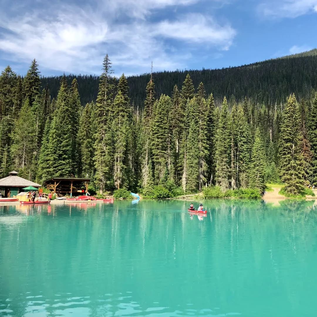 Canoa en un lago turquesa rodeado de bosque en las Montañas Rocosas Canadienses