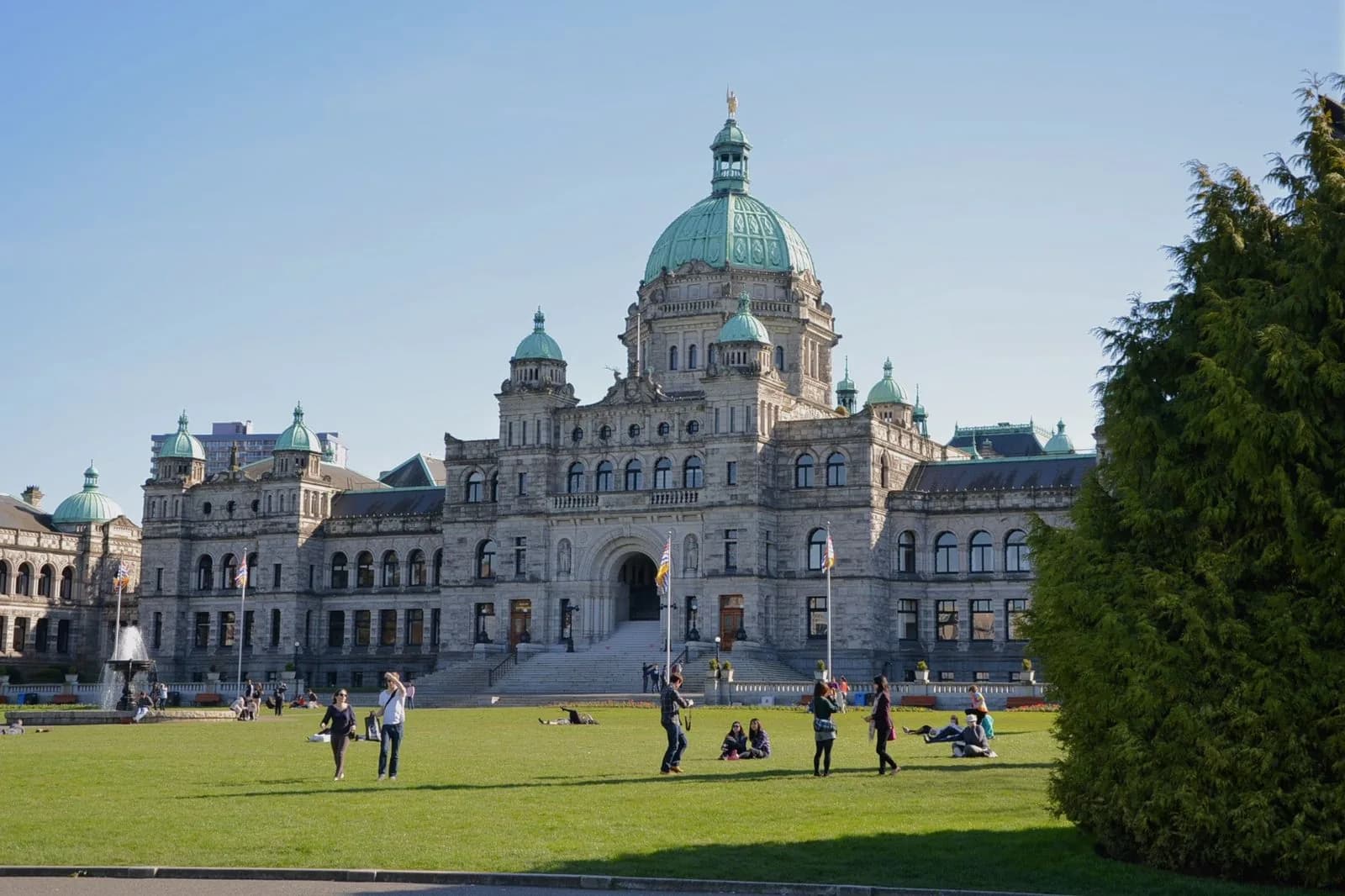 BC Parliament Buildings com fonte e gramado ao fundo, em Victoria