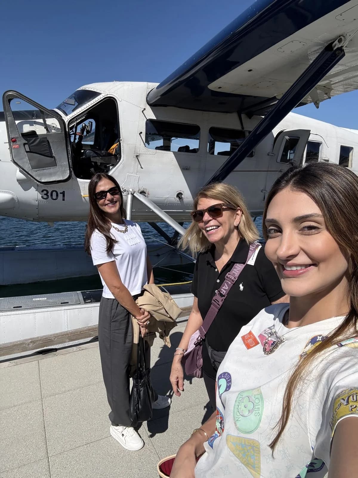 Clientes sorrindo ao lado do hidroavião da Harbour Air em Victoria