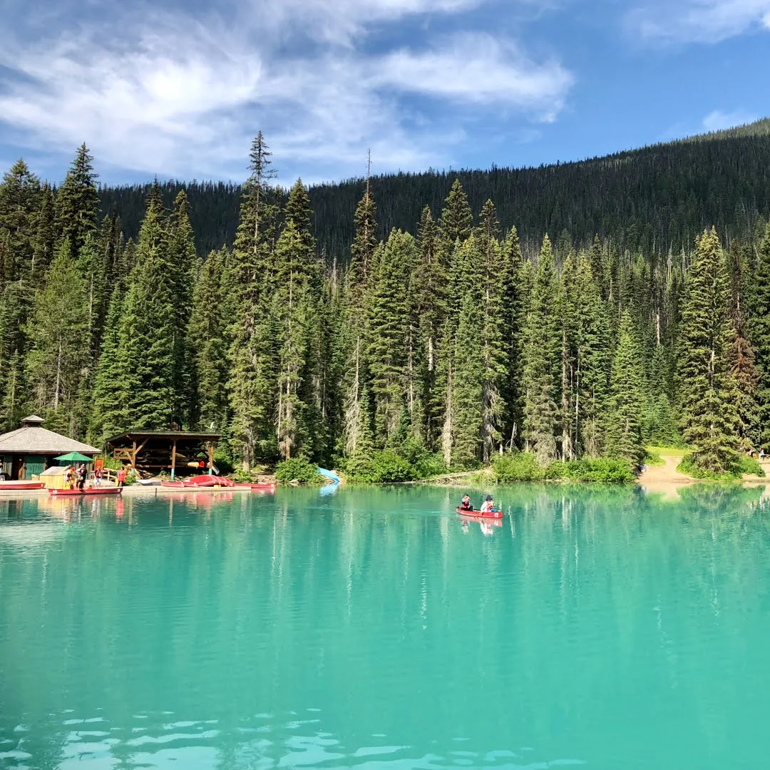 Canoe on a turquoise lake surrounded by forest in the Canadian Rockies